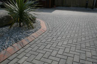 Drive with gray coloured blocks, and shaped red edging stones.