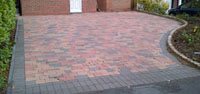 Multi coloured block paved drive, with gray edging stones.