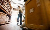 Man pulling pallet truck in Warehouse.