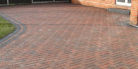 Multi coloured block paved drive, with gray edging stones.