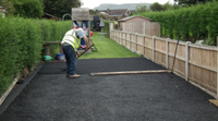 Raking first layer of tarmac; note the gray edging stones.