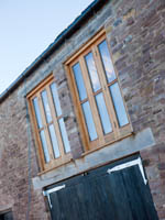 Barn conversion with wooden windows and barn doors.