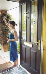 UPVC front door with two ornate glass panels in the top half, solid bottom half, with dark wood grain effect.