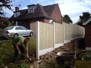 Work in progress - plain gravel boards with concrete posts and vertical close board fencing panels.