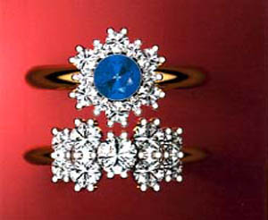 Custom designed jewellery, in the form of two gold rings with diamonds, one with a central sapphire .