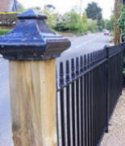 Wrought iron railings alongside a roadside footpath.