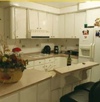 Cream coloured kitchen units with new worktops and breakfast bar.