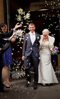 Bride and Groom leaving church, showered in confetti.