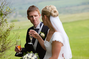 Documentary Wedding photographer Tom Nicholls photographs the Bride and Groom relaxing with a drink after the wedding ceremony.