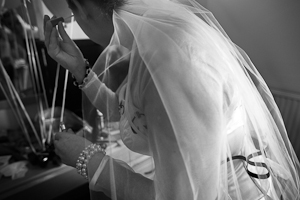 Wedding photographer Tom Nicholls photographs the Bride putting the finishing touches to her make-up.