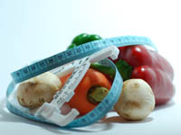 Mushrooms, carrot and peppers representing good nutrition as part of a healthy fitness programme. these are surrounded by a tape measure.