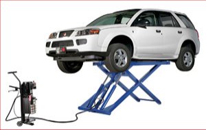 Mid rise scissor lift, fully raised with 4x4 vehicle, transport dolly complete with push button power unit.