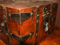 Beautiful looking rosewood effect chest with lock and brass supports, represents secure storage or property.
